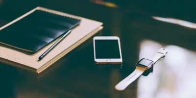 Un escritorio que muestra un iPhone y un Apple Watch.