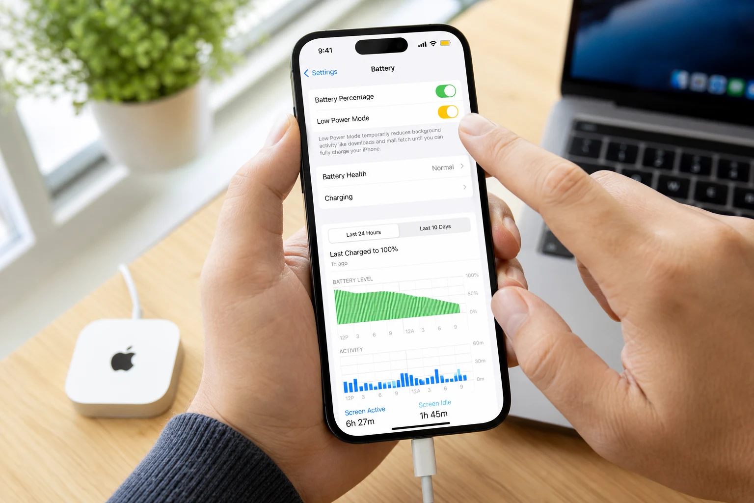 Persona ajustando modo de bajo consumo en iPhone con logo Apple visible