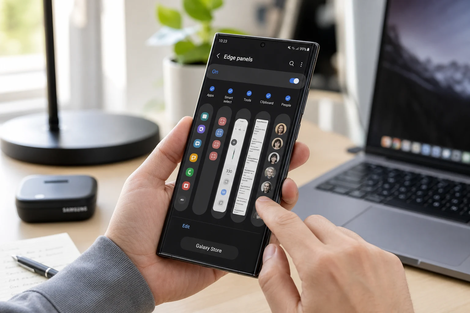 Persona deslizando Edge Panels en Samsung Galaxy en escritorio iluminado