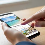 Mano haciendo gesto de captura en smartphone Xiaomi con blog viajero