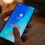 Mano sosteniendo smartphone Xiaomi con advertencia de spam en pantalla