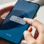 Manos sosteniendo smartphone Xiaomi con menú visible en pantalla