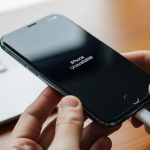 Manos conectando un cable USB-C a un iPhone iluminado