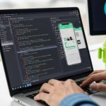 Manos de desarrollador escribiendo en un laptop con código Kotlin