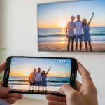 Manos sosteniendo un smartphone Samsung mostrando foto familiar en pantalla