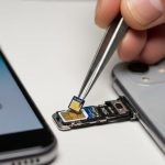 Manos usando pinzas para colocar chip R-SIM en SIM nano